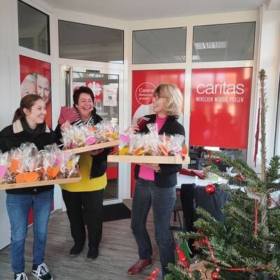 Tirza Wigand (l.) und Daniela Ramb (r.) übergeben die Päckchen mit Keksen und Briefen an Christiane Koch von der Caritas Sozialstation Göttingen / Gleichen. 